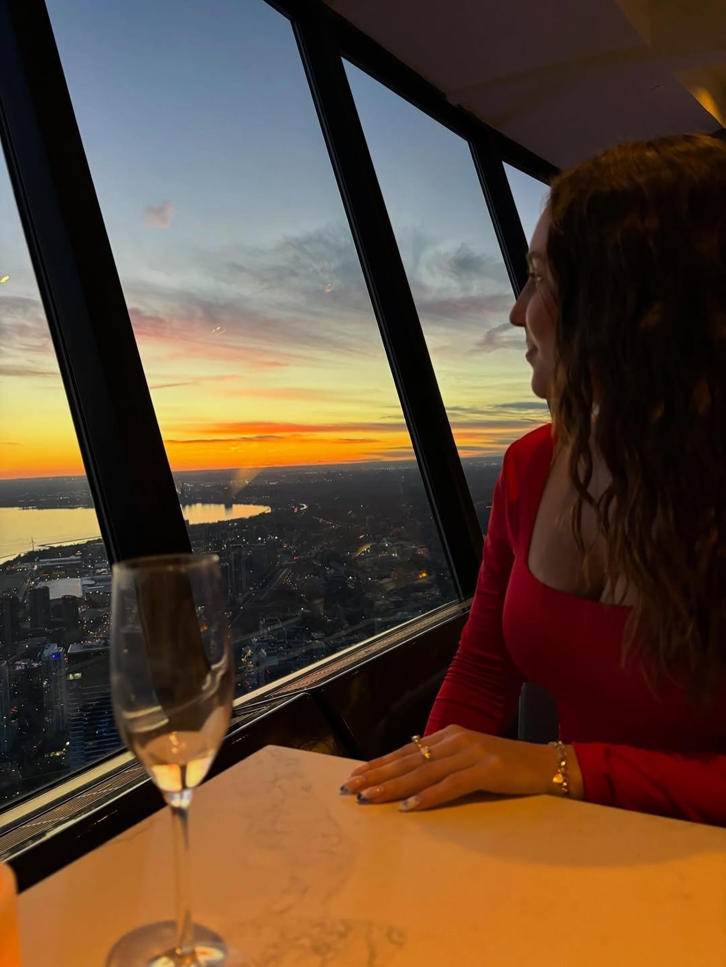 Young woman enjoying sunset views and champagne at 360 Restaurant