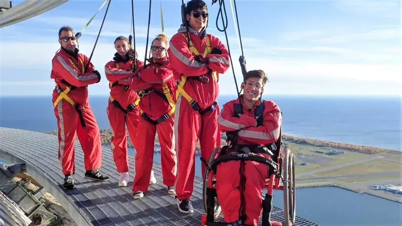 Group of 5 people on EdgeWalk, one participant using a wheelchair.