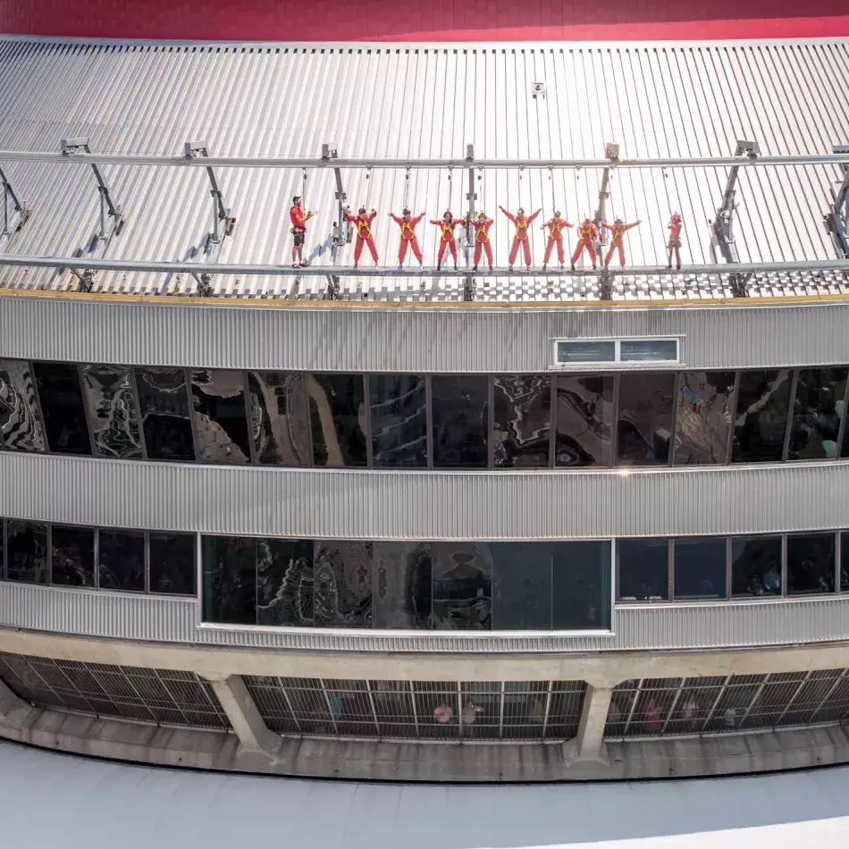Group of people leaning over the edge walk as viewed from eye level.